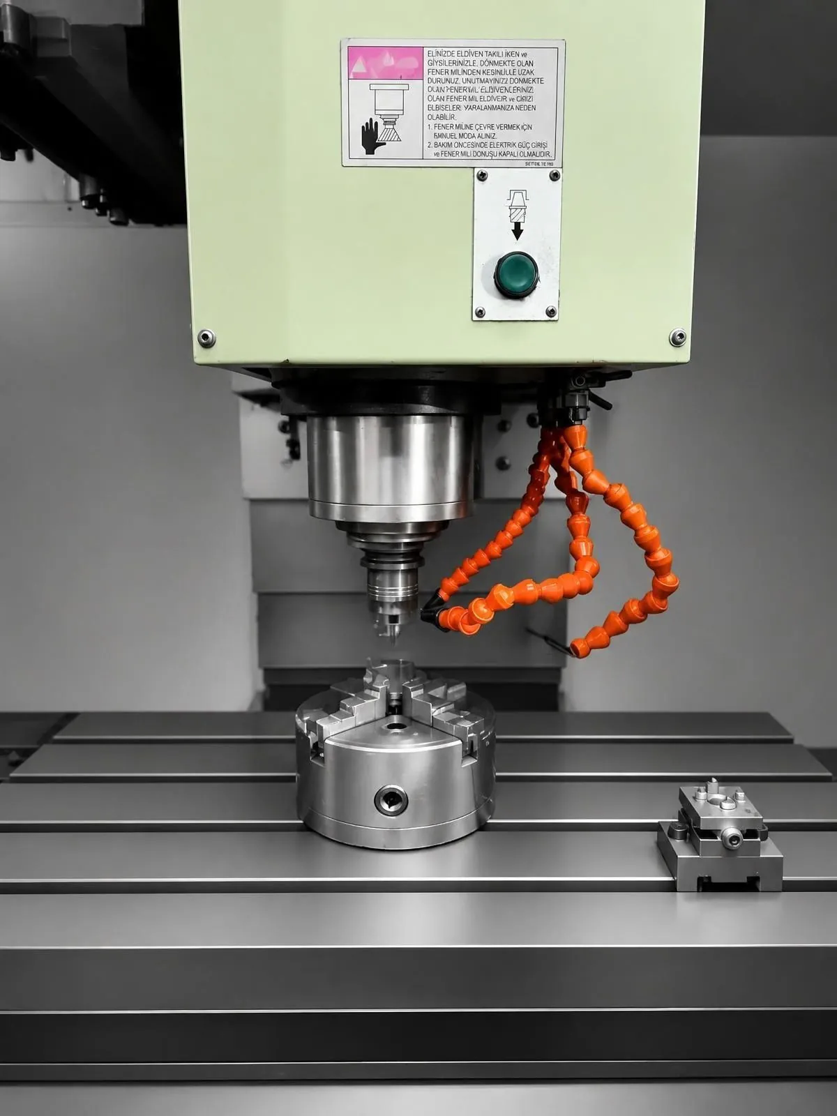 CNC-Frässpindel, abgesenkt über einer runden Spannvorrichtung auf dem Maschinentisch.
